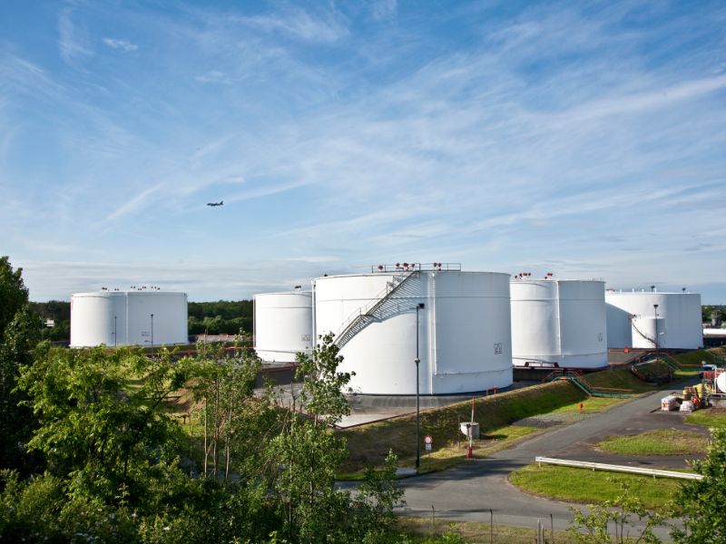 White cylindrical silos next to a road.