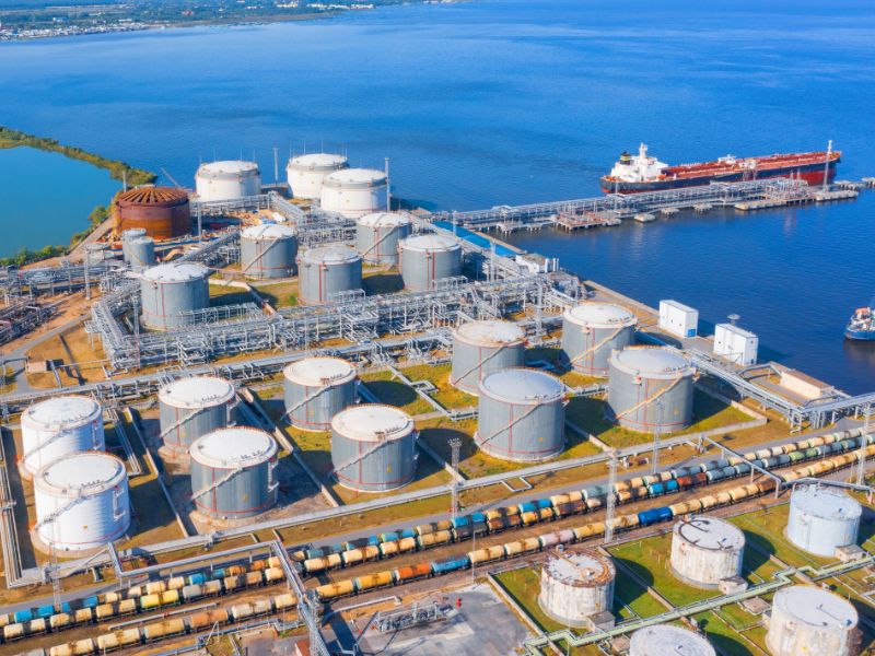 Large silos and dock next to blue water.