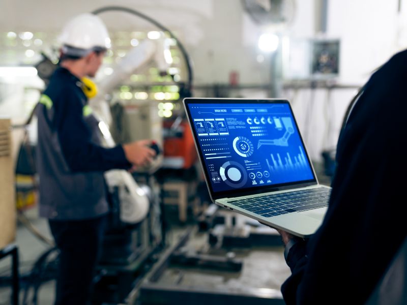 A person holding computer that displays graphs and measurements.