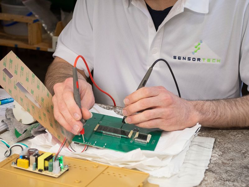 A person soldering a circuit board.